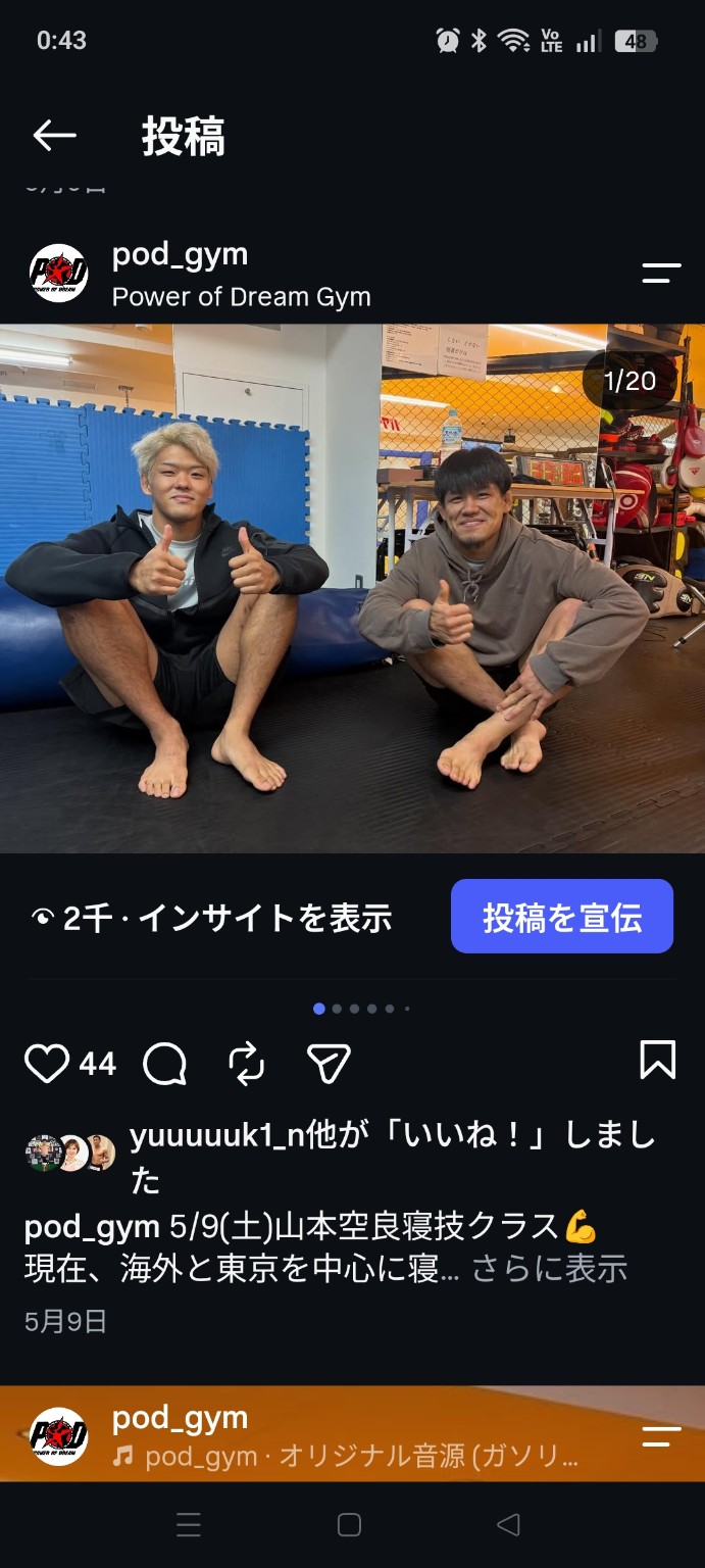 マットに座り笑顔で親指を立てる二人