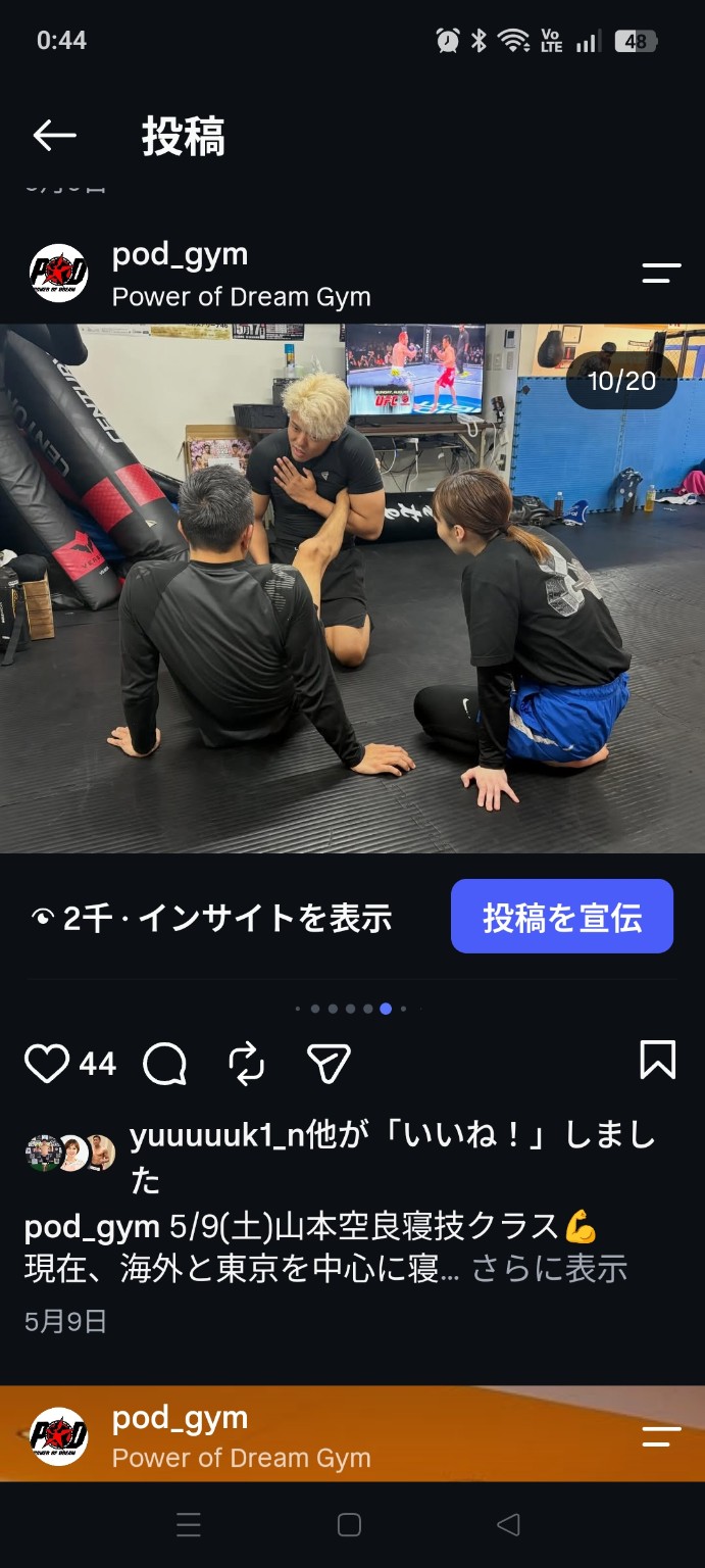 座った参加者に寝技の技術を説明する指導風景