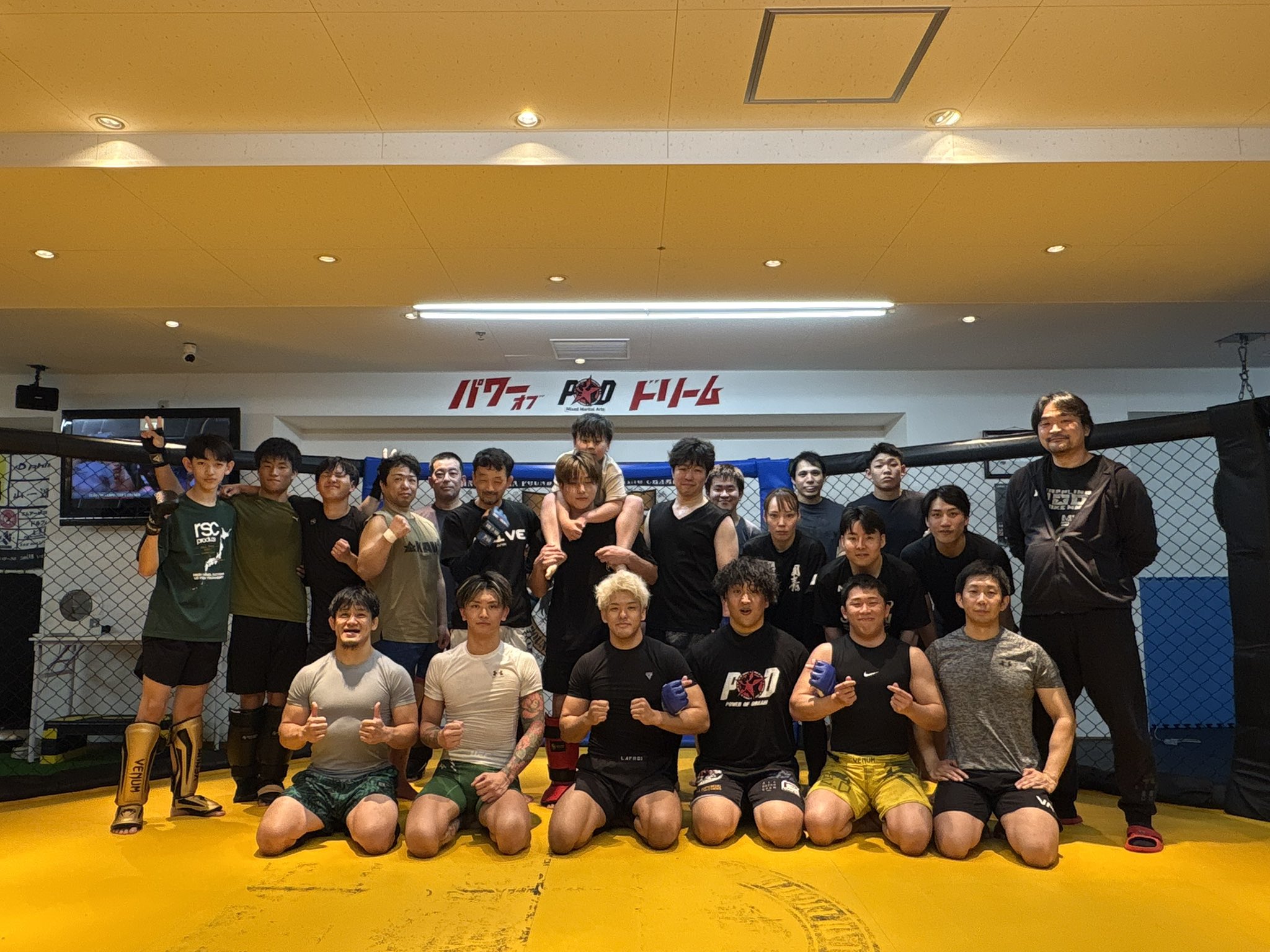 ケージの前で並ぶPOD GYMの仲間たちの集合写真